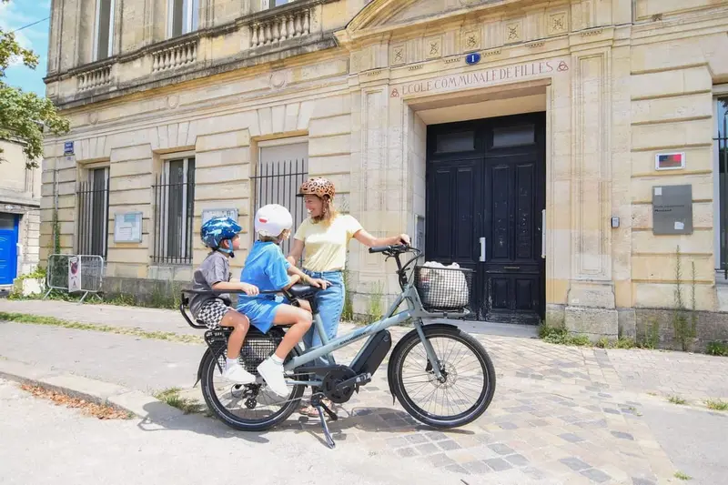 Ouder met twee kinderen op een e-bike met kinderzitjes