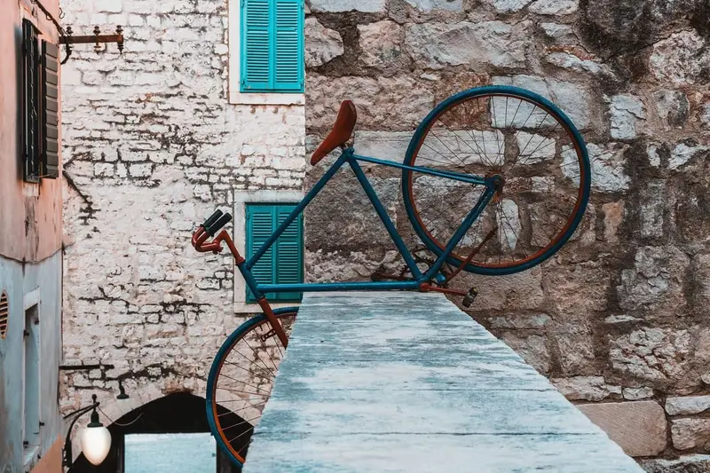 Blauwe fiets tegen een oude stenen muur