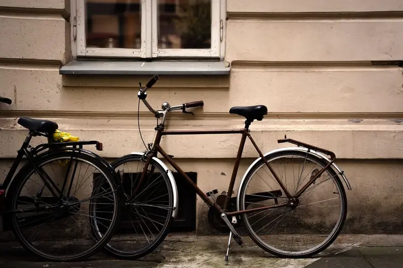 Zwarte herenfiets tegen een lichte gevel